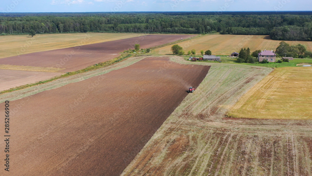 Aerial view drone of harvest field with tractor mows dry grass. Autumn yellow field with a haystack after harvest top view. Harves. Ting in the fields. 