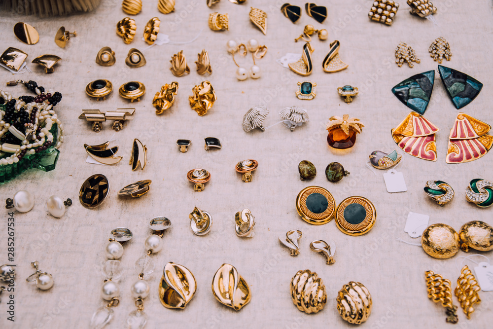 Retro earrings.Jewelry 80-90s.Gold clips.flea market.Counter with jewelry.Vintage  things. Aesthetics. Fair of old things.Sale of unnecessary things.Garage  sale.Weekend Market.Antiques.Second hand. Stock Photo | Adobe Stock