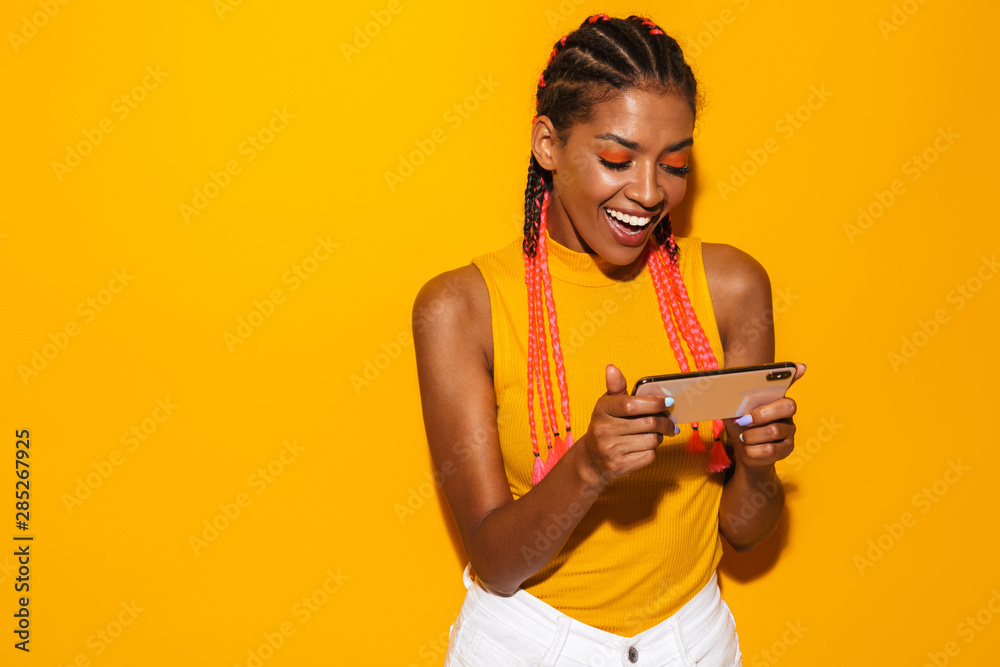 Image of beautiful african american woman with afro braids smiling and holding smartphone - obrazy, fototapety, plakaty 
