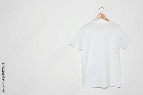 Hanger with blank t-shirt on white background. Mock up for design