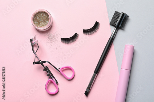 Fototapeta Naklejka Na Ścianę i Meble -  Flat lay composition with false eyelashes and other makeup products on color background