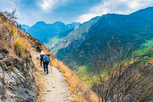 Hiking trail in Tiger Leaping Gorge. Travelers hiking in the mountains. Located 60 kilometres north of Lijiang, Yunnan, China.