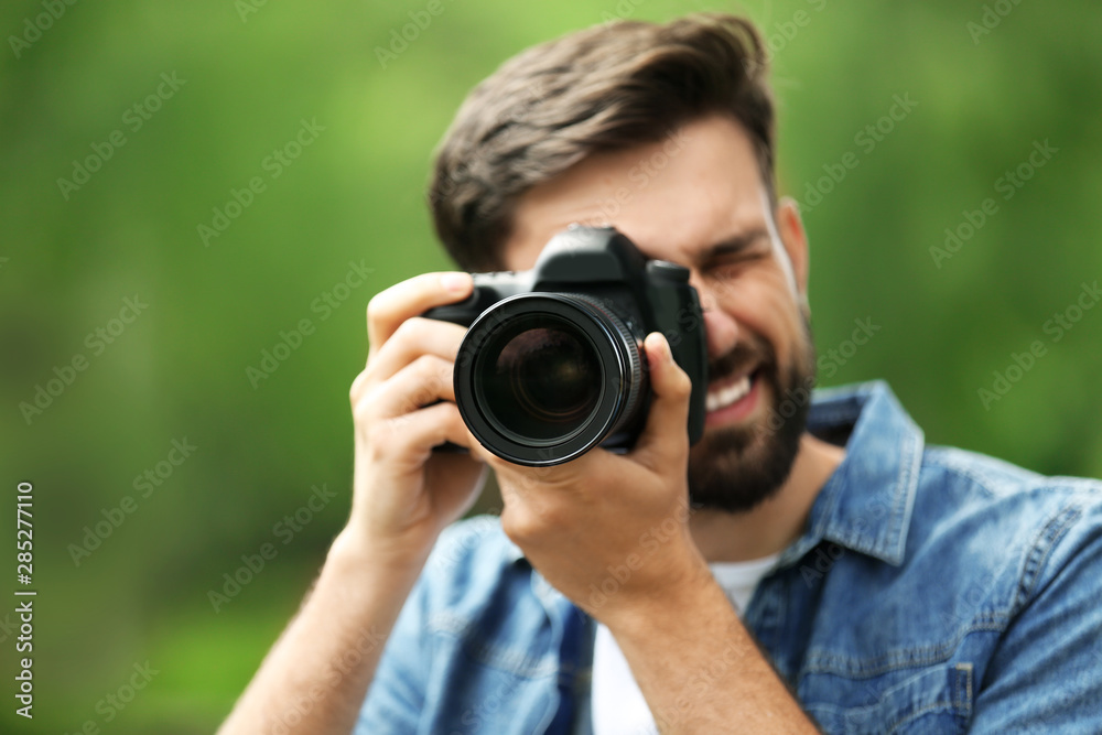 Photographer taking photo with professional camera in park Photographer taking photo with professional camera in park