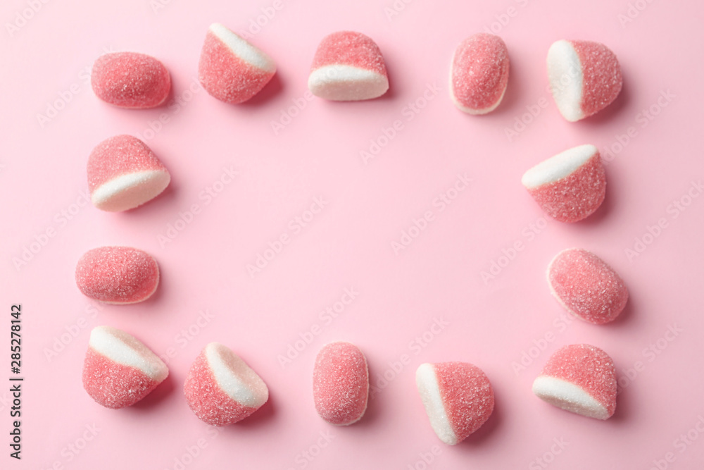 Fototapeta premium Frame of sweet jelly candies on pink background, flat lay. Space for text