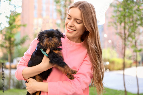 Young woman with adorable Brussels Griffon dog outdoors photo