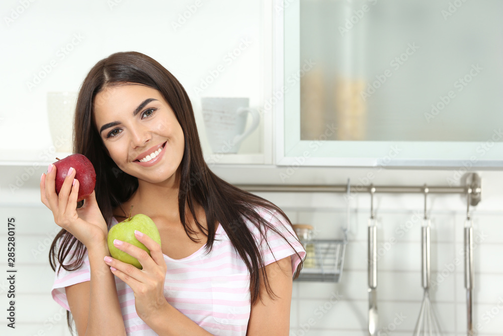 Happy woman holding fresh apples in kitchen. Space for text Happy woman holding fresh apples in kitchen. Space for text
