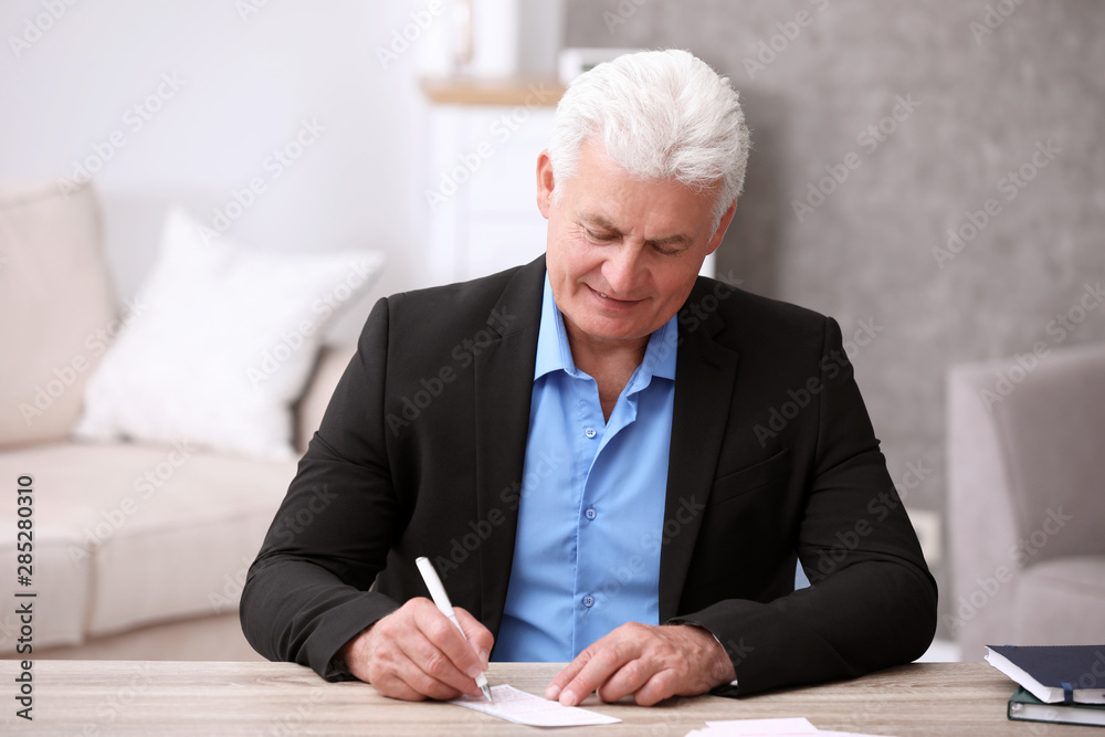 Portrait of senior man filling out lottery ticket at table Portrait of senior man filling out lottery ticket at table