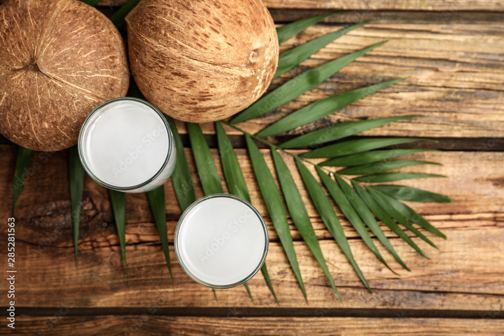 Flat lay composition with glasses of coconut water on wooden background