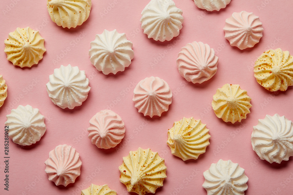 Flat lay with white, pink and yellow meringues on pink background Flat lay with white, pink and yellow meringues on pink background