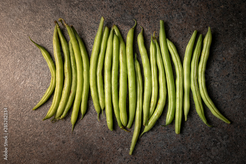 Green runner beans on dark background