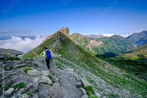 Hiker reaching a pass in the Ecrins National Park, french Alps