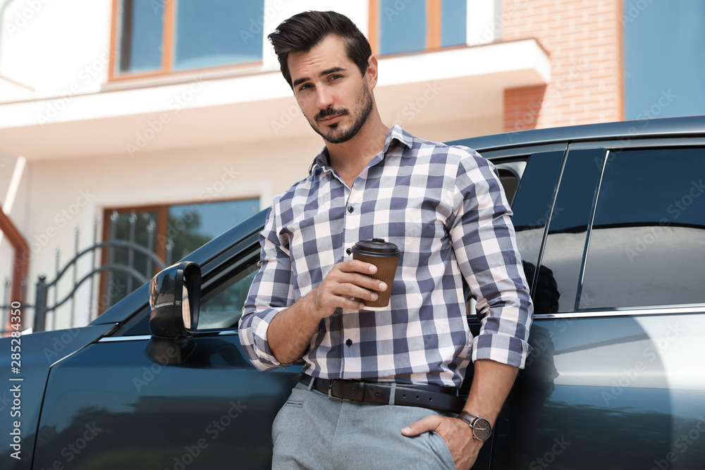Attractive young man with cup of coffee near luxury car outdoors Attractive young man with cup of coffee near luxury car outdoors