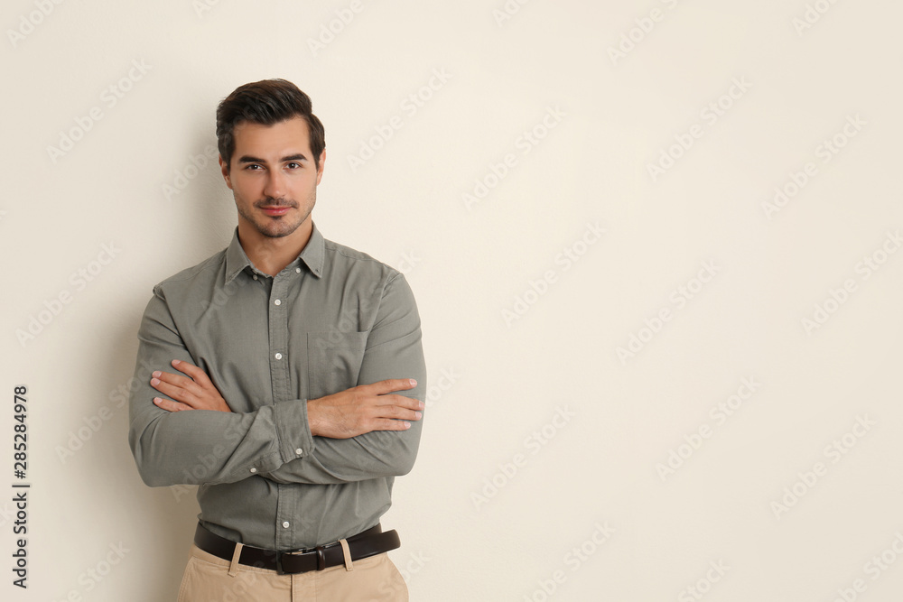 Obraz premium Young male teacher on beige background. Space for text