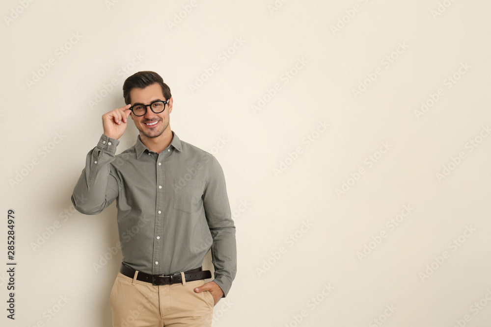 Young man with glasses on beige background. Space for text Young man with glasses on beige background. Space for text