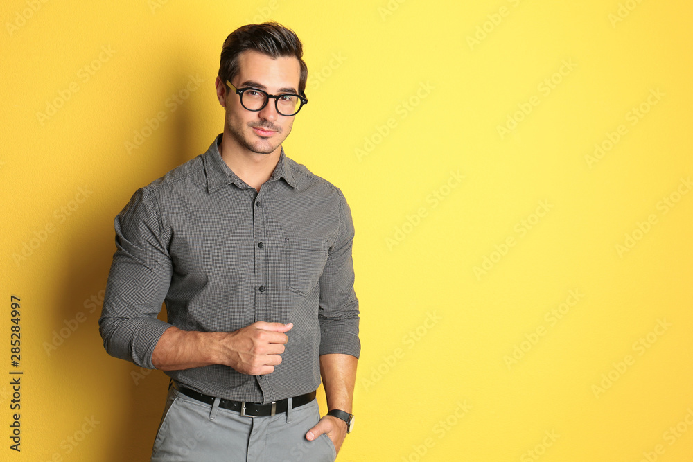 Obraz premium Young male teacher with glasses on yellow background. Space for text