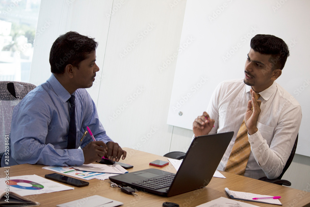 Two businessmen discussing project in conference room Two businessmen discussing project in conference room