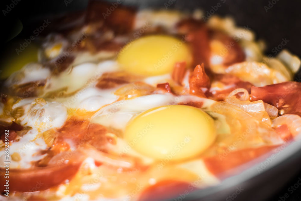 Fried eggs with onions, tomato and pepper, cooking in a pan, breakfast, healthy lifestyle Fried eggs with onions, tomato and pepper, cooking in a pan, breakfast, healthy lifestyle