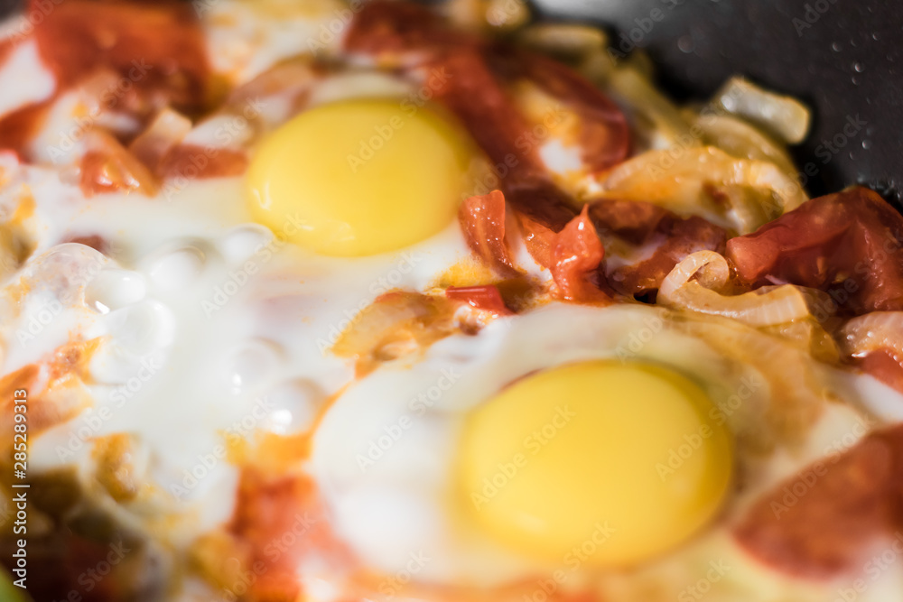 Fried eggs with onions, tomato and pepper, cooking in a pan, breakfast, healthy lifestyle Fried eggs with onions, tomato and pepper, cooking in a pan, breakfast, healthy lifestyle