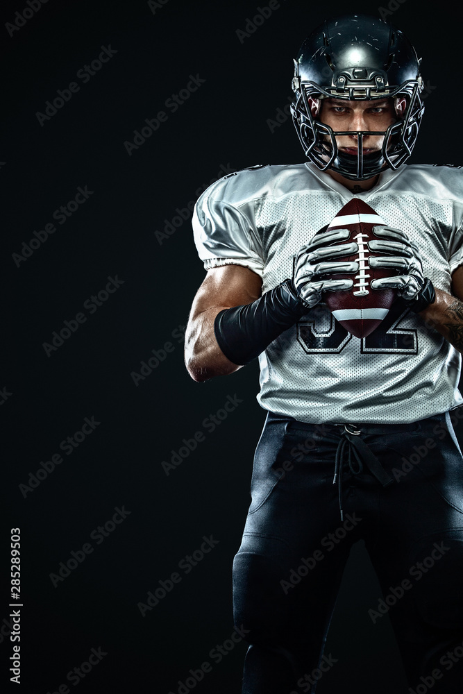 American football sportsman player in helmet on black background. Sport and motivation. Team sports.