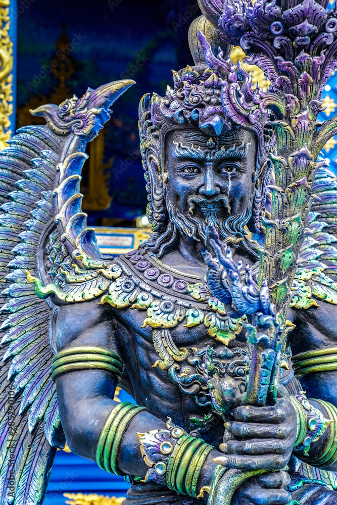 Fototapeta premium The Blue - Turquiose metalic God statue in Thai blue temple, at the North of Thailand.