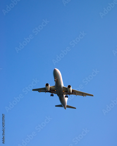 Plane landing in the blue sky. Island of Santorini, in Greece.