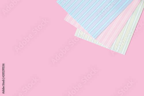 Office: pink copyspace background, and a lot of cardboard sheet in stripes, bright colors.