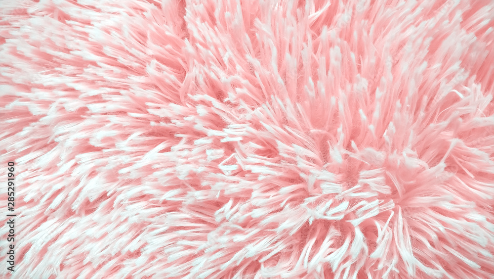Pink sheepskin rug background. Wool texture. Fabric made of faux fur with long nap used for clothing and furniture and bedspreads. Detail of soft hairy skin material.