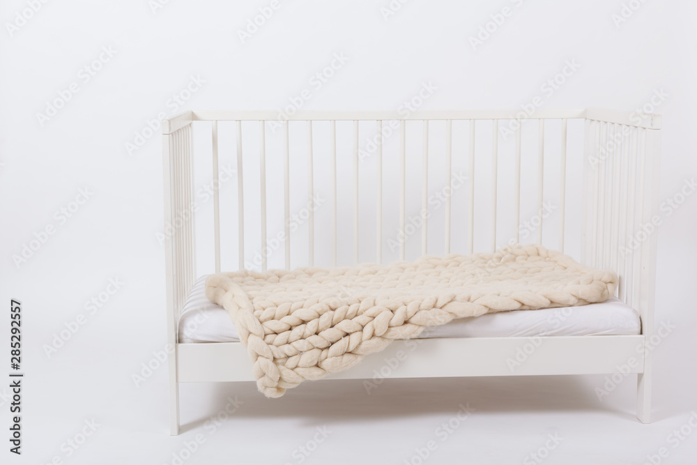 Plaid Merino wool hand-knitted, lying on a child's bed. Plaid Merino wool hand-knitted, lying on a child's bed.