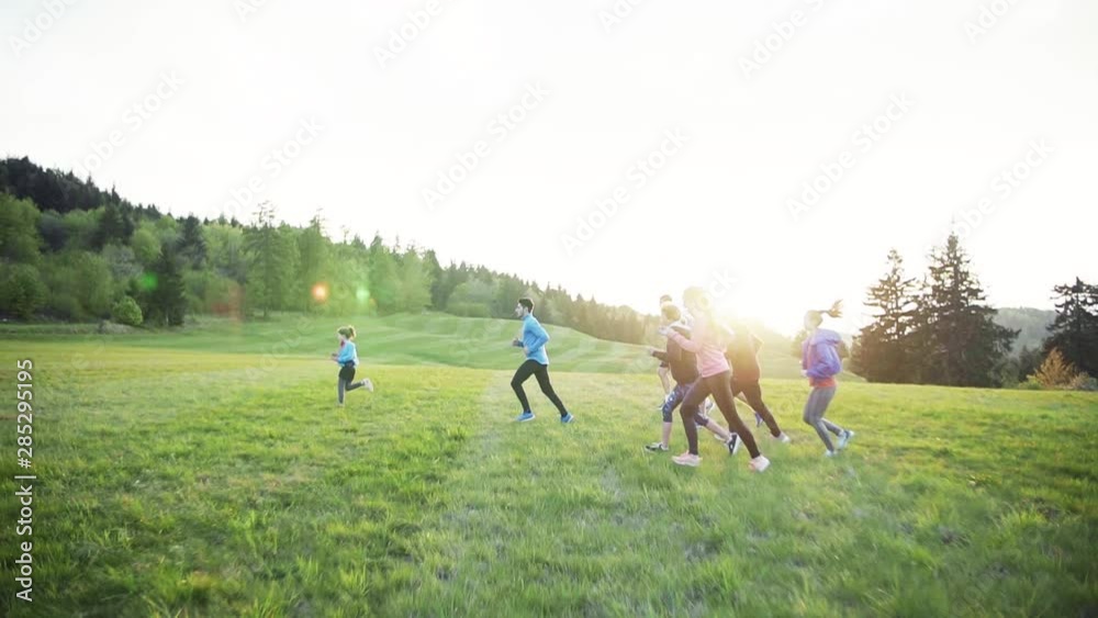 Large group of people cross country running in nature at sunset. Large group of people cross country running in nature at sunset.