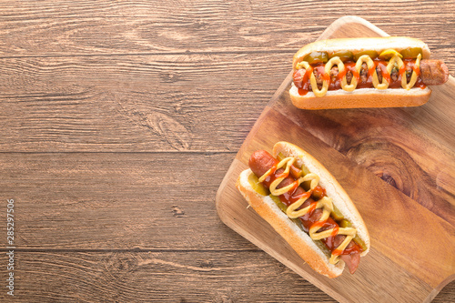 Hot dog with grilled sausage  mustard  and ketchup  onions  and greens on Paper background