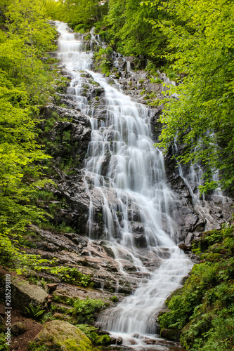 Long exposure of powerful Piljski waterfall cascading down the rocky cliff during spring on Old mountain