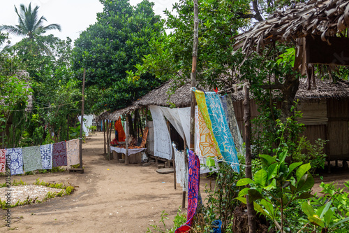 Village with wooden cottages and colorful towels for sale at Lokobe nature strict reserve in Madagascar, Nosy Be, Africa
