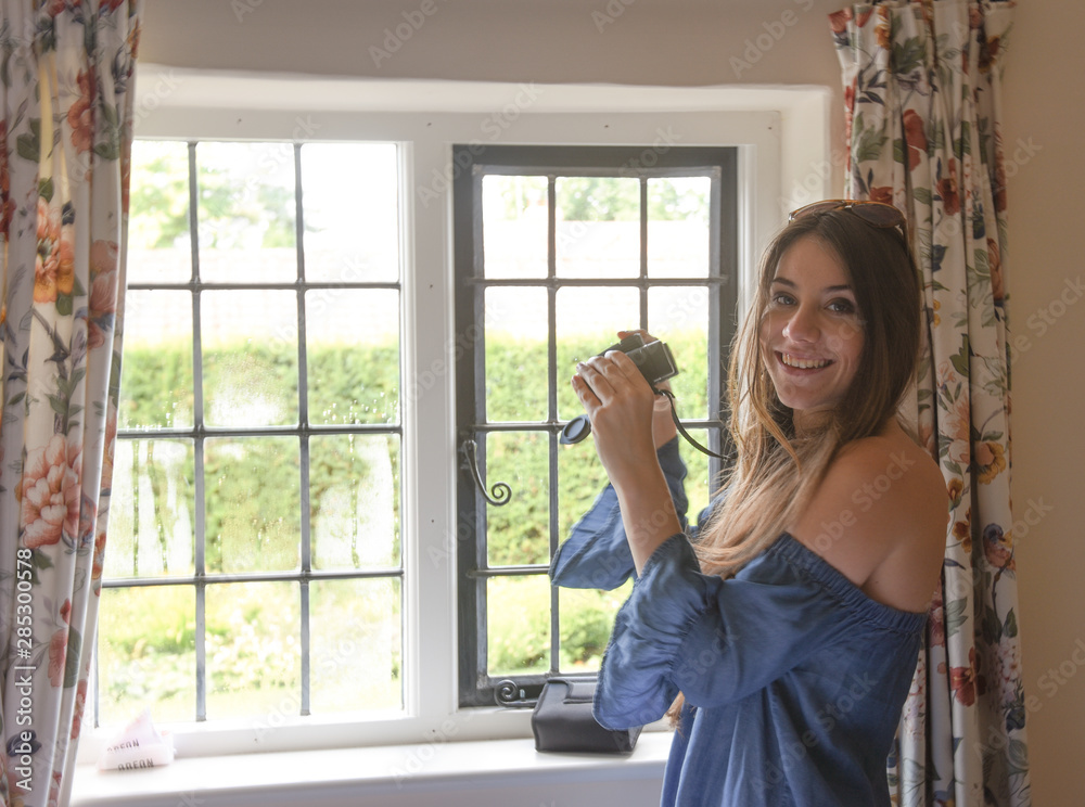 young woman looking through the window with binoculars young woman looking through the window with binoculars