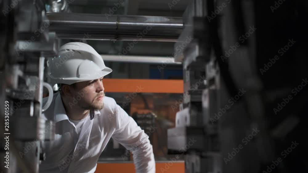 The inspector in a white helmet checks the state of the gas installation in the production laboratory. 4k The inspector in a white helmet checks the state of the gas installation in the production laboratory. 4k