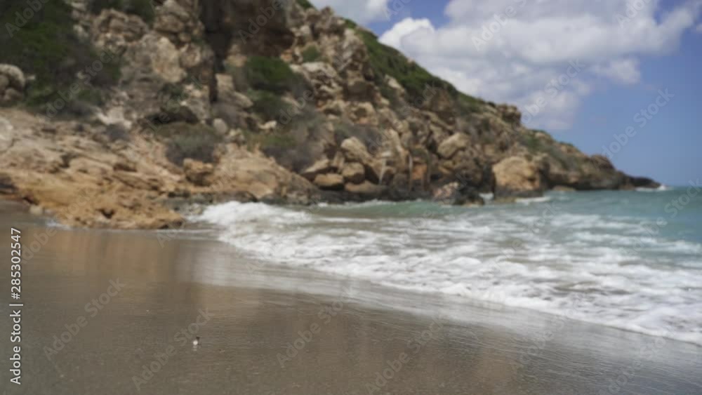 Waves splashing on seashore by rock in slow motion Waves splashing on seashore by rock in slow motion