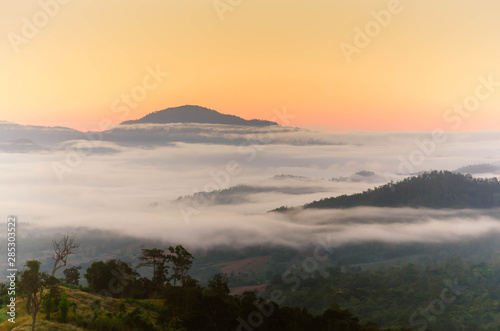 Fog and complex of mountain landscape with colorful twilight.