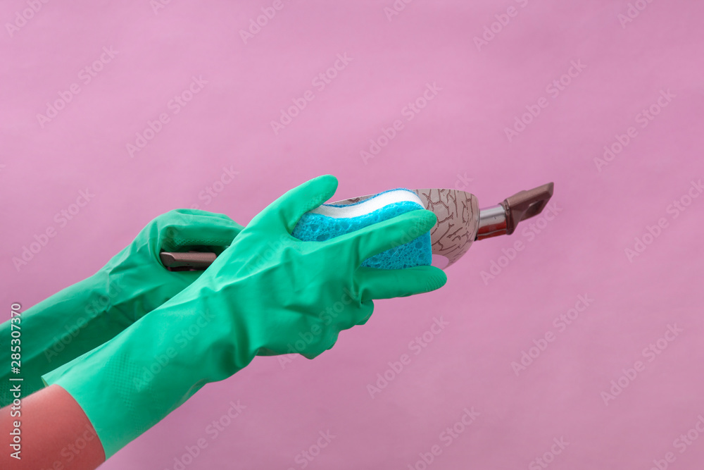 Hand in green protective glove washing a pan - obrazy, fototapety, plakaty 