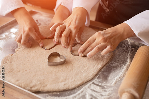 Anonymous kids preparing cookies in bakery