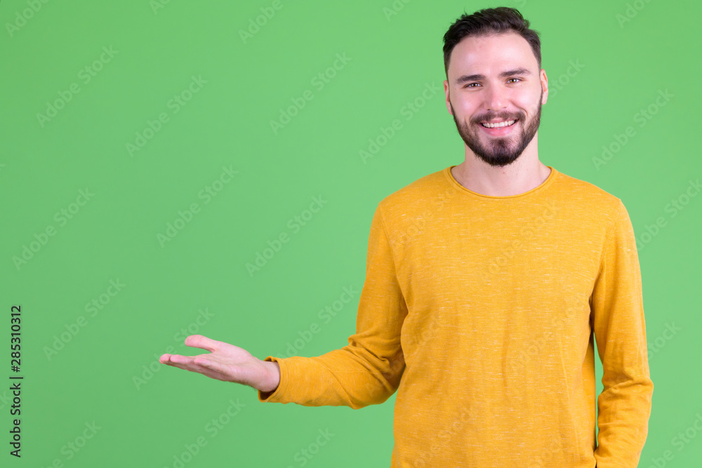 Happy young handsome bearded man showing something Happy young handsome bearded man showing something