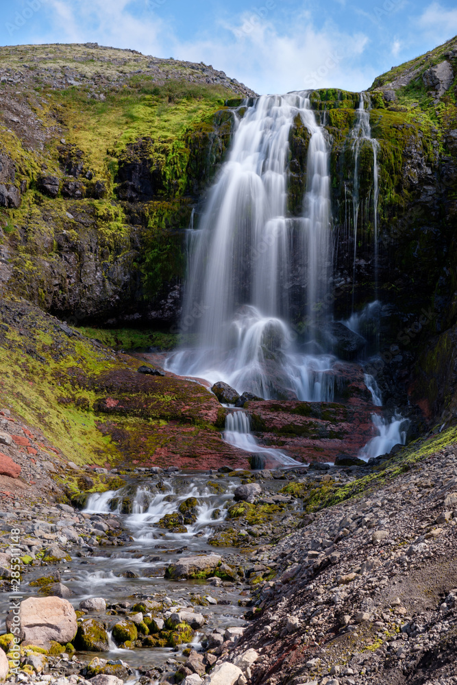 High waterfall in Westfjords mountain landscape, Iceland