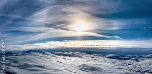 Drone photo of winter mountains around Hemavan, Tarnaby villages, Lappland, Northern Sweden. Sunny day, cold blue air skies with winter halo, no wind