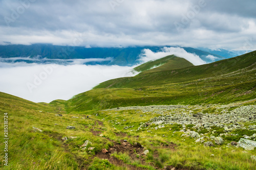 Kazbegi  Georgia - Mount Kazbegi landscape with dramatic clouds up in the trekking and hiking route.