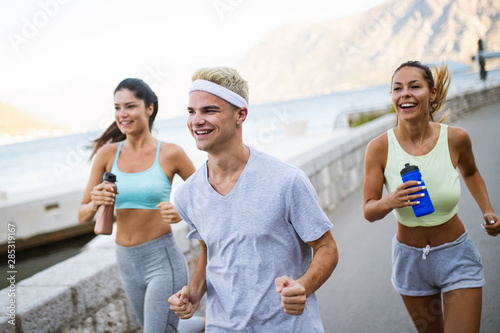 Group of young people friends running outdoors at seaside