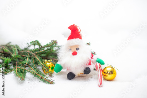 decorative cute brown rat sitting on the branches of the Christmas tree with a Christmas decor and Santa Claus. The rat is a symbol Of the new year 2020