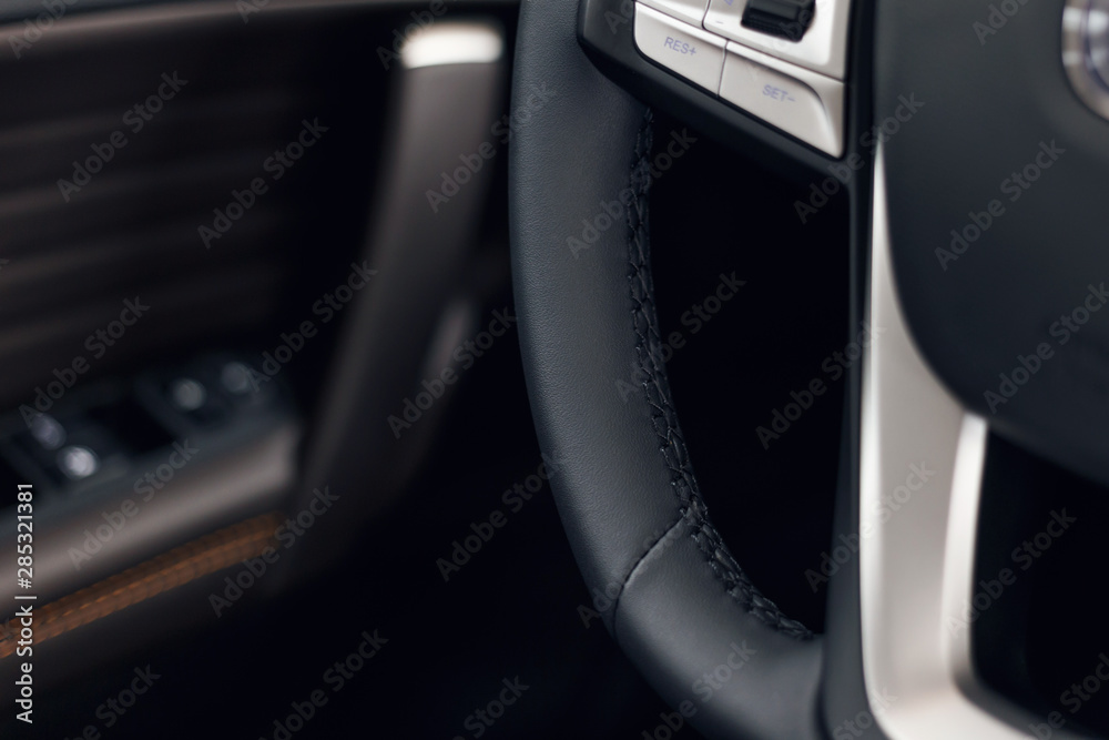 Multimedia leather steering wheel in a modern expensive car. Perforated leather steering wheel. Modern car interior details. Car detailing. Selective focus