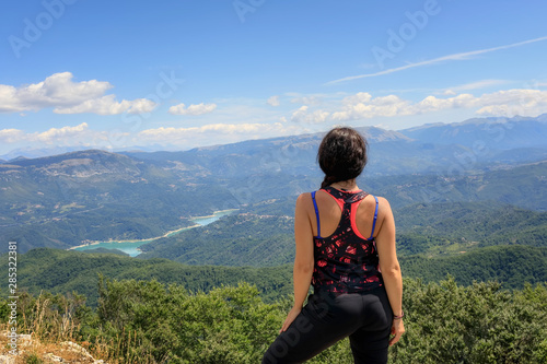Hiker girl in the mountains scrutinizes the landscape