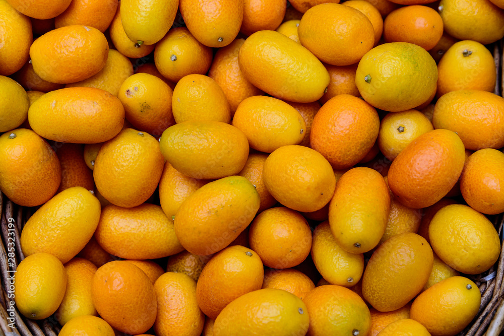 Bunch of fresh ripe organic kumquats in display for sale at a street food market, soft focus Bunch of fresh ripe organic kumquats in display for sale at a street food market, soft focus