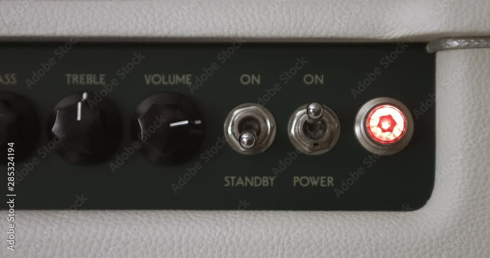 Guitar Player Switching On Tube Amp And Adjusting Volume Knob. Music Related 4K Concept Guitar Player Switching On Tube Amp And Adjusting Volume Knob. Music Related 4K Concept