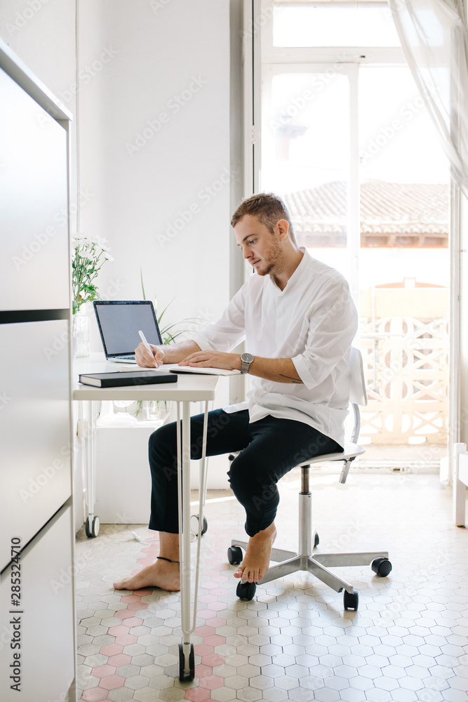 Man at working desk using laptop Man at working desk using laptop