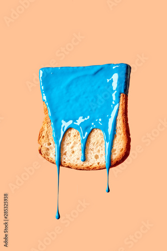 Dry freshly toast in a blue paint on a pasrel background with copy space. photo